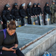 A woman checks her phone while police officers monitor the situation near a CVS pharmacy that was looted and burned by rioters on Monday after the funeral of Freddie Gray, on April 29, 2015, in Baltimore, Maryland.
Andrew Burton/Getty Images